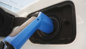 upwards shot of a royal blue electric charger plugged into a car