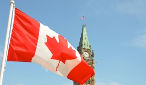 image of canadian flag over parliament hill in Ottawa