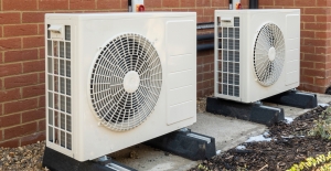 two heat pumps installed outside a brick cladded home
