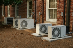 a row of residential heat pumps installed outside brick home
